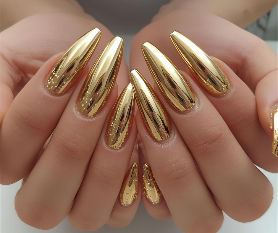 Gold nail polish on a person's fingernails against a neutral background