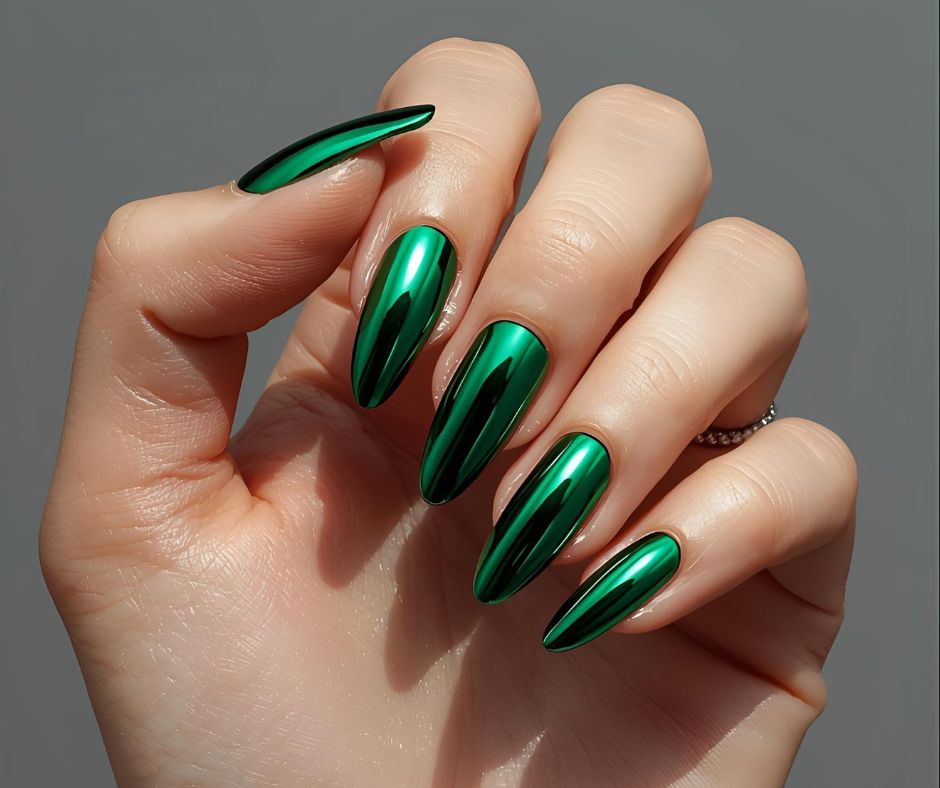 Hand with green metallic press on fake. nail  on a grey background