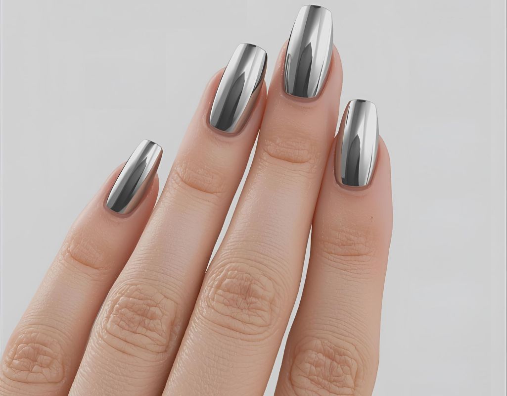Hand with metallic silver nail polish on a light gray background