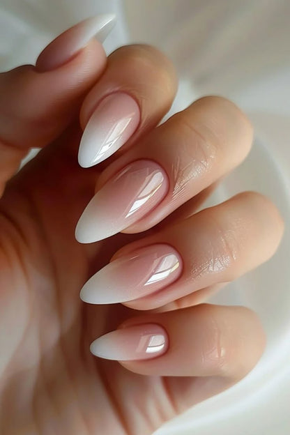 Close-up of a hand with almond-shaped press on nails featuring a gradient fake nail design.